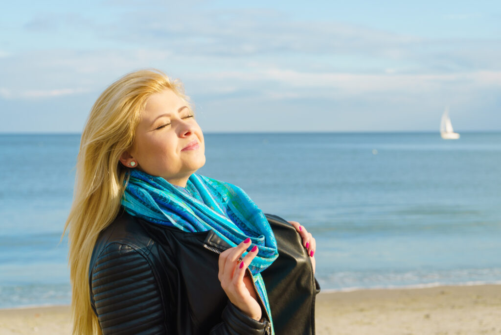 Woman relaxing on beach, cold day